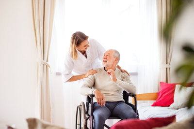 woman talking to an elderly man in a wheelchair